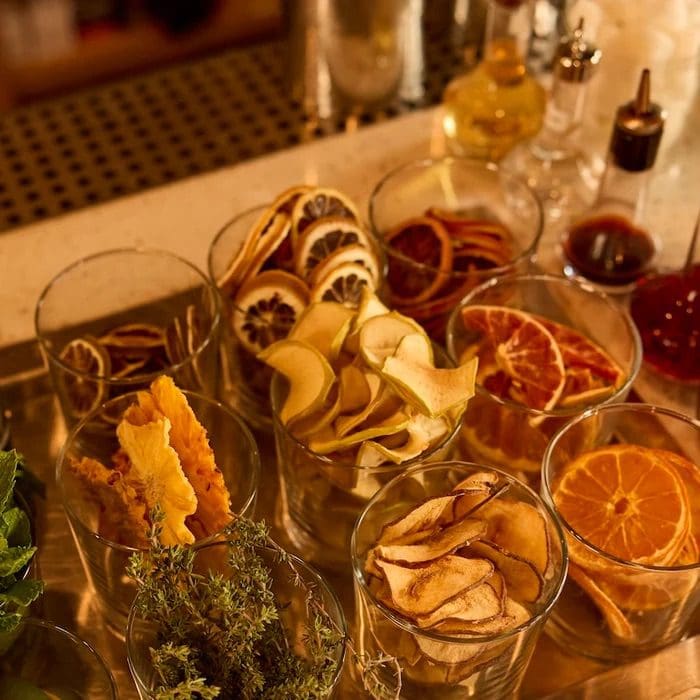 A table with many glasses of wine and fruit.