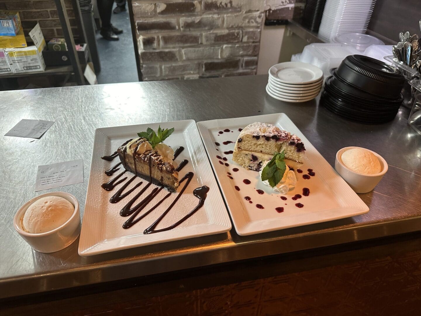 Two plates of food on a table with cups.