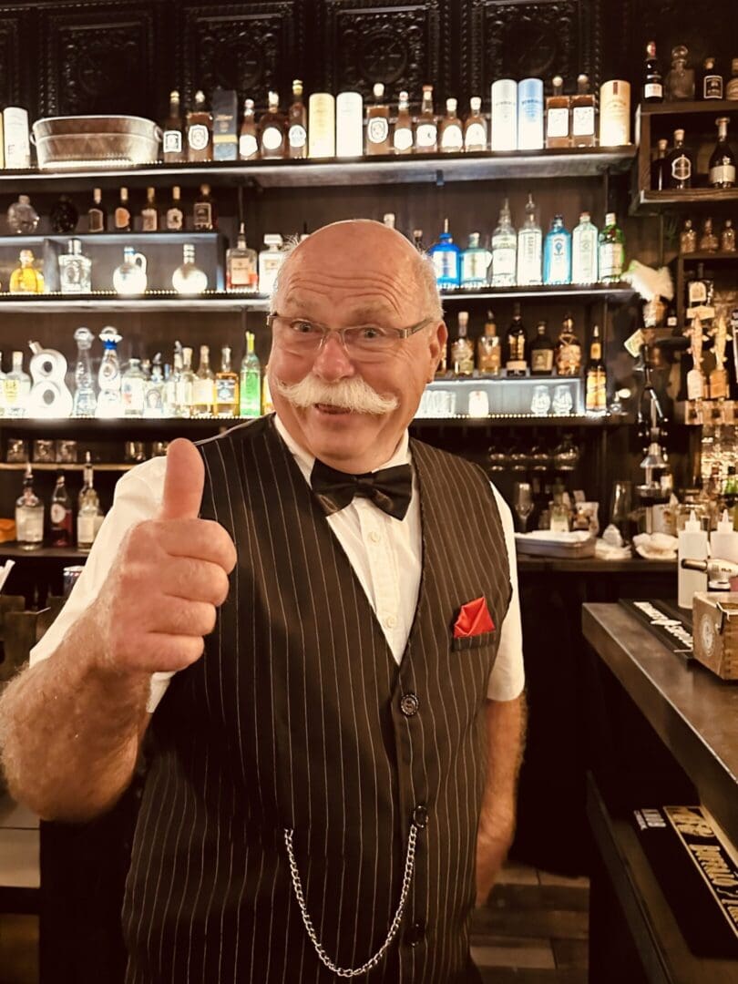 A man giving the thumbs up at a bar.