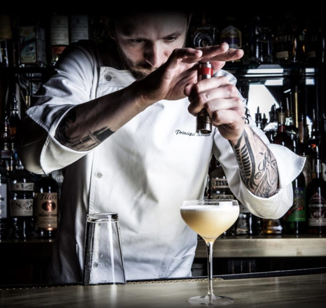 A person standing at a bar with a drink