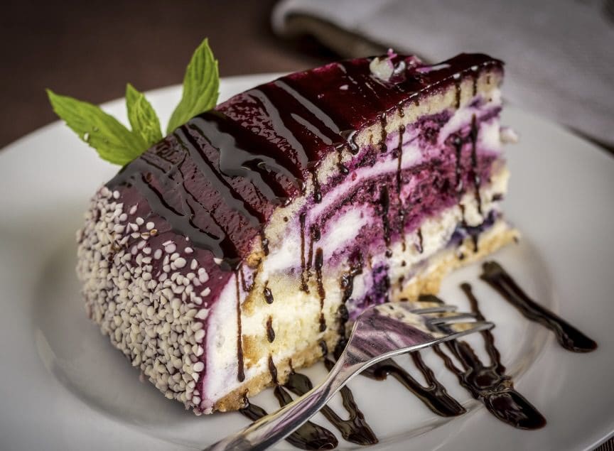 A piece of cake with chocolate and berries on top.